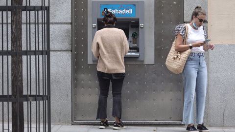 Dos mujeres en un cajero de una sucursal de banco Sabadell. Foto de archivo. Dos mujeres en un cajero de una sucursal de banco Sabadell. Foto de archivo.