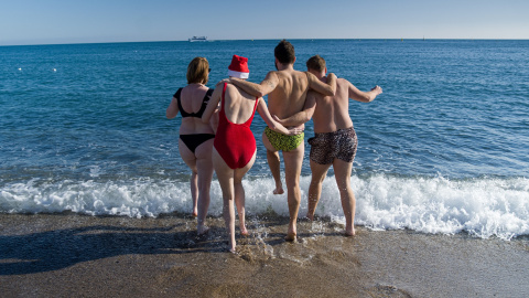 Unos jóvenes se bañan en la playa de la Barceloneta, a 25 de diciembre de 2022, en Barcelona. Unos jóvenes se bañan en la playa de la Barceloneta, a 25 de diciembre de 2022, en Barcelona.