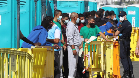 Varios migrantes esperan en el muelle de Arguineguín (Gran Canaria) a que les tomen las huellas dactilares y la filiación. Varios migrantes esperan en el muelle de Arguineguín (Gran Canaria) a que les tomen las huellas dactilares y la filiación.