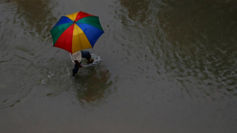 Un hombre con un paraguas camina por una zona inundada en Rajbiraj, distrito de Saptari, Nepal. EFE/EPA/NARENDRA SHRESTHA