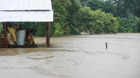 Una mujer y un niño, en medio de las inundaciones en la aldea de Topa en el districto de Saptari, Nepal. EFE/EPA/NARENDRA SHRESTHA