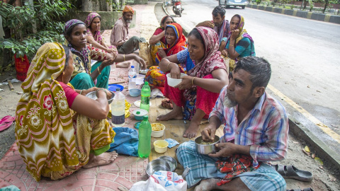 Una familia come en una calle de Bangladesh.