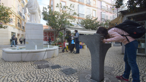 Una joven, bebiendo de una fuente pública en Cádiz. Una joven, bebiendo de una fuente pública en Cádiz.