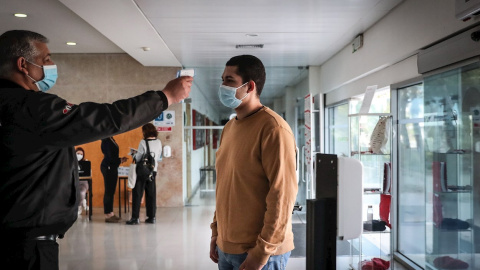 Personal de seguridad toma la temporada a un estudiante en la entrada de la facultad de Derecho de la Universidad de Lisboa. Personal de seguridad toma la temporada a un estudiante en la entrada de la facultad de Derecho de la Universidad de Lisboa.