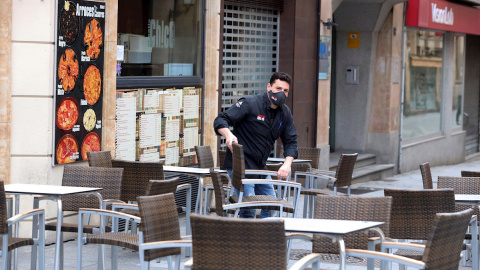 Un camarero prepara la terraza de un bar de Salamanca. Castilla y León ha abierto este viernes las terrazas de la hostelería, salvo en la capital burgalesa.