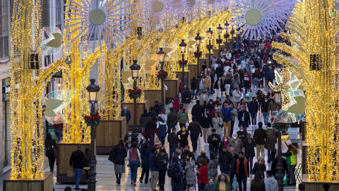 Numerosas personas observan el alumbrado de Navidad de la calle Larios, en Málaga.