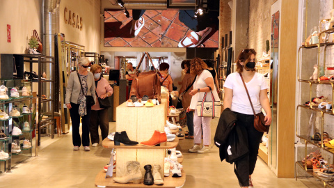 Una dona mira sabates a la botiga Casas de Portal de l'Àngel el primer diumenge d'obertura de comerços grans a Barcelona . Una dona mira sabates a la botiga Casas de Portal de l'Àngel el primer diumenge d'obertura de comerços grans a Barcelona .