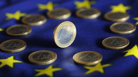 Monedas de euro sobre una bandera de la UE. Monedas de euro sobre una bandera de la UE.