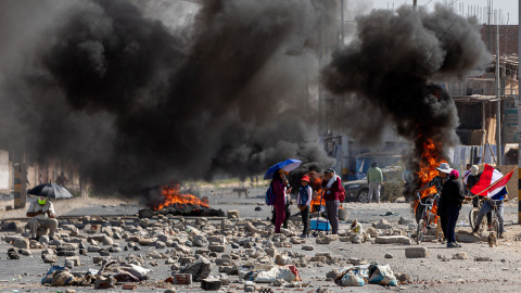 Varias personas caminan entre barricadas durante una manifestación en la ciudad de Tacna, a 11 de enero de 2023. Varias personas caminan entre barricadas durante una manifestación en la ciudad de Tacna, a 11 de enero de 2023.