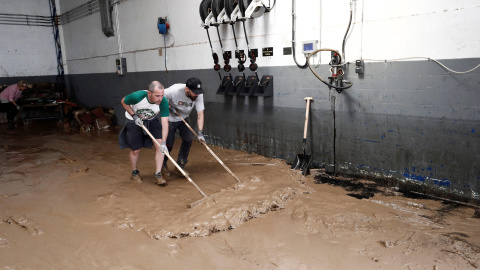 Dos de los vecinos de la localidad de Tafalla que han comenzado esta mañana las actividades de recuperación del municipio, tras las fuertes lluvias caídas desde primeras horas de la tarde de ayer. Las precipitaciones también han causado importantes da