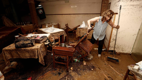 Una vecina de la localidad navarra de Tafalla limpia el interior de un local tras las fuertes lluvias caídas desde primeras horas de la tarde de ayer, que han causado importantes daños materiales en poblaciones como Olite, Pueyo, Pitillas o Beire.- EFE/