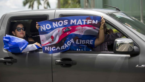 04/07/2018.- Un grupo de personas agita una bandera desde un vehículo durante un plantón denominado "Cadena Humana de Rotonda a Rotonda", a una distancia 3.4 km en la carretera hacia Masaya, hoy, miércoles 4 de julio de 2018, en Managua (Nicaragua). De 04/07/2018.- Un grupo de personas agita una bandera desde un vehículo durante un plantón denominado "Cadena Humana de Rotonda a Rotonda", a una distancia 3.4 km en la carretera hacia Masaya, hoy, miércoles 4 de julio de 2018, en Managua (Nicaragua). De