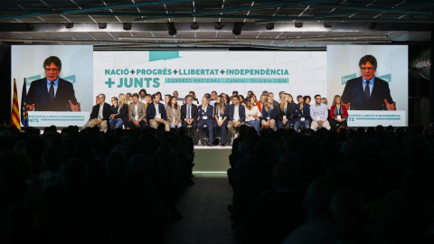 El secretario general de Junts, Jordi Turull, escucha la intervención de Carles Puigdemont (en las pantallas) durante el Congreso del partido que se celebró en Calella (Barcelona). El secretario general de Junts, Jordi Turull, escucha la intervención de Carles Puigdemont (en las pantallas) durante el Congreso del partido que se celebró en Calella (Barcelona).