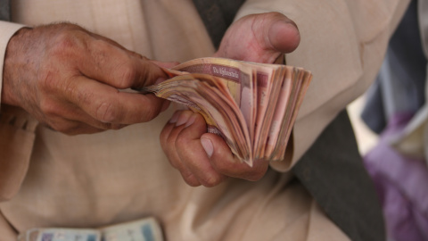 Un hombre cuenta efectivo en un mercado de cambio de dinero en Kabul, Afganistán Un hombre cuenta efectivo en un mercado de cambio de dinero en Kabul, Afganistán
