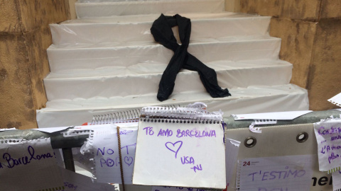 Un gran crespó negre presideix l'entrada al carrer Puigmartí, on els visitants deixen missatges de condol. Foto: Elena Parreño