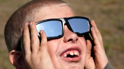Un niño con unas gafas de sol especiales para observar el eclipse de Sol. REUTERS/Rick Wilking Un niño con unas gafas de sol especiales para observar el eclipse de Sol. REUTERS/Rick Wilking