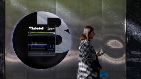 Una mujer pasa por delante de un cajero automático del Banco Sabadell en la Gran Via de Bilbao. REUTERS/Vincent West Una mujer pasa por delante de un cajero automático del Banco Sabadell en la Gran Via de Bilbao. REUTERS/Vincent West
