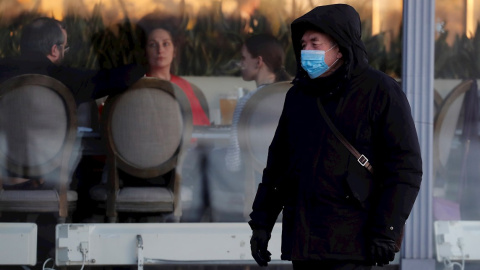 09/12/2020.- Un hombre ruso con mascarilla pasa frente a un restaurante en San Petersburgo.