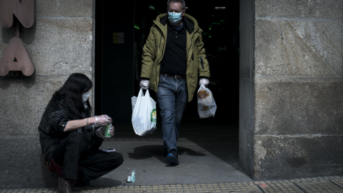 Una mujer pidiendo limosna en la entrada de un supermercado. Una mujer pidiendo limosna en la entrada de un supermercado.