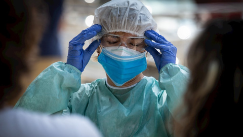 Una sanitaria se prepara antes de entrar en la carpa provisional para realizar test para detectar el coronavirus, en una imagen de archivo. Una sanitaria se prepara antes de entrar en la carpa provisional para realizar test para detectar el coronavirus, en una imagen de archivo.