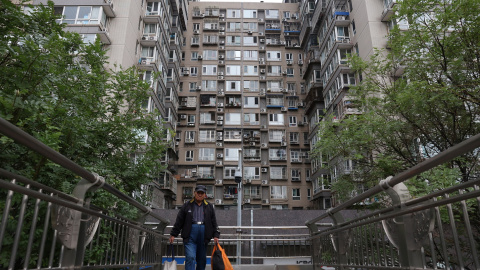 Un hombre cruzo un puente cerca de un edificio residencial en Pekín. REUTERS/Florence Lo Un hombre cruzo un puente cerca de un edificio residencial en Pekín. REUTERS/Florence Lo