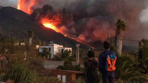 Una pareja observa cómo la lava emerge de la erupción volcánica de Cumbre Vieja, en la isla canaria de La Palma este 29 de septiembre de 2021. Una pareja observa cómo la lava emerge de la erupción volcánica de Cumbre Vieja, en la isla canaria de La Palma este 29 de septiembre de 2021.