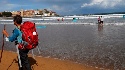 Una mujer pasea por la playa de San Lorenzo de Gijón. Una mujer pasea por la playa de San Lorenzo de Gijón.
