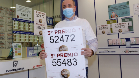 Luis Vázquez, propietario de la administración número 2 de Arroyo de la Encomienda (Valladolid), muestra los números 52472 y 55483, tercer y quinto premio de la lotería de Navidad. Luis Vázquez, propietario de la administración número 2 de Arroyo de la Encomienda (Valladolid), muestra los números 52472 y 55483, tercer y quinto premio de la lotería de Navidad.