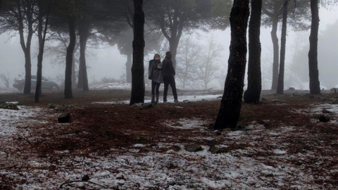 Varias personas aprovechan el temporal, para disfrutar de la nieve caída. / EFE