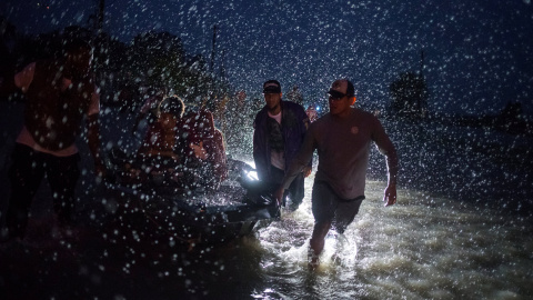Varios voluntarios ayudan a empujar un barco con evacuados durante una tormenta causada por lel huracán Harvey en el este de Houston, Texas, (EEUU).- REUTERS / Adrees Latif