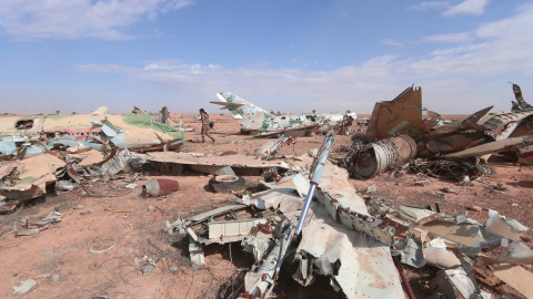 Un miliciano de las Fuerzas de Siria Democrática pasa junto a los restos de aviones destruidos ne la ciudad de Raqqa. - REUTERS Un miliciano de las Fuerzas de Siria Democrática pasa junto a los restos de aviones destruidos ne la ciudad de Raqqa. - REUTERS