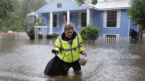 Doug Glassel camina por el agua mientras sujeta una bolsa de alimentos recuperados de su casa inundada en Spring, en el estado de Texas, en Estados Unidos. EFE Doug Glassel camina por el agua mientras sujeta una bolsa de alimentos recuperados de su casa inundada en Spring, en el estado de Texas, en Estados Unidos. EFE