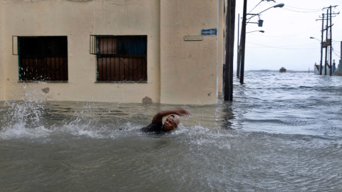 Un hombre nada por una calle inundada en La Habana. - EFE