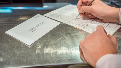 Una persona rellena unos documentos tras solicitar el voto por correo, en Madrid a 14 de junio de 2023 Una persona rellena unos documentos tras solicitar el voto por correo, en Madrid a 14 de junio de 2023