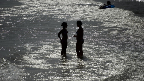 Dos personas se refrescan en la playa de Sitges en una imagen de archivo. Dos personas se refrescan en la playa de Sitges en una imagen de archivo.