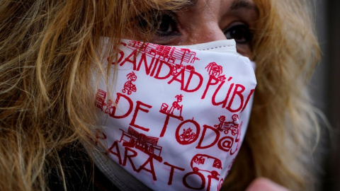 Una mujer con mascarilla, con lemas a favor de la sanidad pública, en una manifestación en Madrid. Una mujer con mascarilla, con lemas a favor de la sanidad pública, en una manifestación en Madrid.