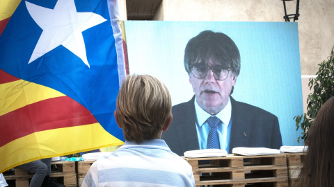 Un niño observa la intervención telemática de Puigdemont en el mitin central del partido JxCAT, a 16 de julio de 2023, en en Amer, Girona, Catalunya (España). Junts per Catalunya ha elegido la ciudad natal del expresidente de la Generalitat y de la fo Un niño observa la intervención telemática de Puigdemont en el mitin central del partido JxCAT, a 16 de julio de 2023, en en Amer, Girona, Catalunya (España). Junts per Catalunya ha elegido la ciudad natal del expresidente de la Generalitat y de la fo