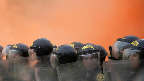 Los agentes de la policía antidisturbios hacen guardia mientras los manifestantes antigubernamentales protestan contra la presidenta de Perú, Dina Boluarte, en Lima, Perú, el 19 de julio de 2023. Los agentes de la policía antidisturbios hacen guardia mientras los manifestantes antigubernamentales protestan contra la presidenta de Perú, Dina Boluarte, en Lima, Perú, el 19 de julio de 2023.