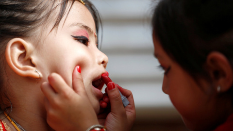 Una niña le pinta los labios a su amiga. REUTERS/ Navesh Chitrakar Una niña le pinta los labios a su amiga. REUTERS/ Navesh Chitrakar