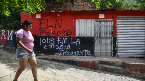 Una mujer pasa frente a una casa con un grafiti de la guerrilla del ELN cerca de Cacuta, Colombia, a 4 de julio. Una mujer pasa frente a una casa con un grafiti de la guerrilla del ELN cerca de Cacuta, Colombia, a 4 de julio.
