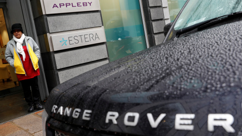 Una mujer se resguarda de la lluvia en la entrada de las oficinas de Appleby en Jersey.REUTERS/Darren Staples Una mujer se resguarda de la lluvia en la entrada de las oficinas de Appleby en Jersey.REUTERS/Darren Staples