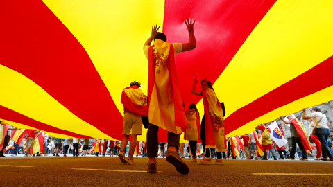 Varias personas bajo una gigantesca bandera catalana en la marcha en Barcelona por el día de la Fiesta Nacional. REUTERS/Gonzalo Fuentes Varias personas bajo una gigantesca bandera catalana en la marcha en Barcelona por el día de la Fiesta Nacional. REUTERS/Gonzalo Fuentes