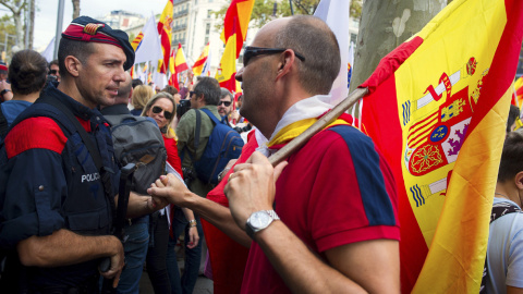 Un hombre con la bandera de España saluda a un mosso de esquadra durante la manifestación convocada por Societat Civil Catalana, Espanya i Catalans y otras entidades contrarias a la independencia con motivo del Día de la Fiesta Nacional. EFE/Andreu Dal Un hombre con la bandera de España saluda a un mosso de esquadra durante la manifestación convocada por Societat Civil Catalana, Espanya i Catalans y otras entidades contrarias a la independencia con motivo del Día de la Fiesta Nacional. EFE/Andreu Dal