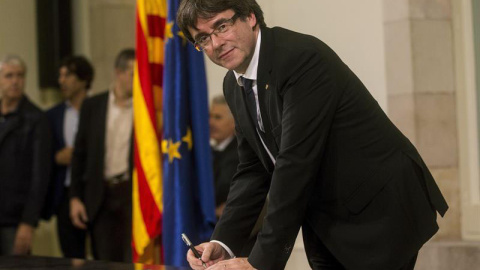 Puigdemont firma el documento de adhesión a la República catalana después de comparecer ante el pleno del Parlament para trasladar los resultados de la jornada del 1-O. | QUIQUE GARCÍA (EFE) Puigdemont firma el documento de adhesión a la República catalana después de comparecer ante el pleno del Parlament para trasladar los resultados de la jornada del 1-O. | QUIQUE GARCÍA (EFE)