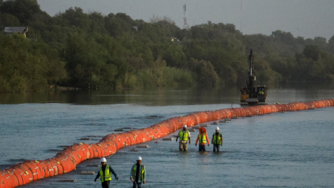 Los trabajadores pasan junto a las boyas colocadas para disuadir a los migrantes que intentan cruzar el río Grande en Eagle Pass (Texas) desde México a EEUU. REUTERS/Adrees Latif Los trabajadores pasan junto a las boyas colocadas para disuadir a los migrantes que intentan cruzar el río Grande en Eagle Pass (Texas) desde México a EEUU. REUTERS/Adrees Latif