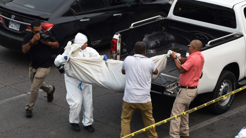 El personal de medicina forense traslada el cuerpo de uno de los jóvenes asesinados a tiros por pandilleros en las inmediaciones de un centro comercial en Tegucigalpa el 26 de abril de 2023. El personal de medicina forense traslada el cuerpo de uno de los jóvenes asesinados a tiros por pandilleros en las inmediaciones de un centro comercial en Tegucigalpa el 26 de abril de 2023.
