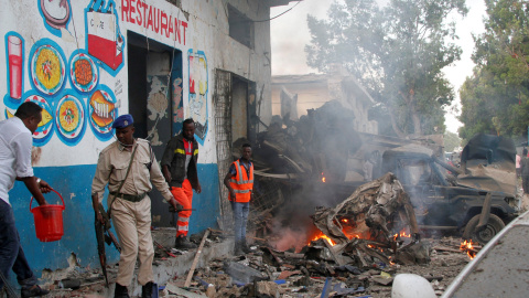 Policías somalíes investigan uno de los coches bomba que han sido detonados en la capital de Somalia. REUTERS/Feisal Omar Policías somalíes investigan uno de los coches bomba que han sido detonados en la capital de Somalia. REUTERS/Feisal Omar