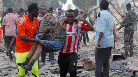 Ciudadanos asisten a un hombre, herido tras la explosión de un coche bomba en Somalia. REUTERS/Feisal Omar Ciudadanos asisten a un hombre, herido tras la explosión de un coche bomba en Somalia. REUTERS/Feisal Omar