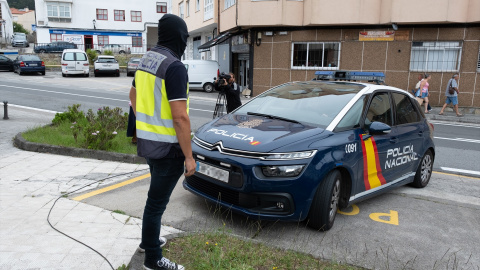 Un agente y un coche de la Policía Nacional. Imagen de archivo. Un agente y un coche de la Policía Nacional. Imagen de archivo.