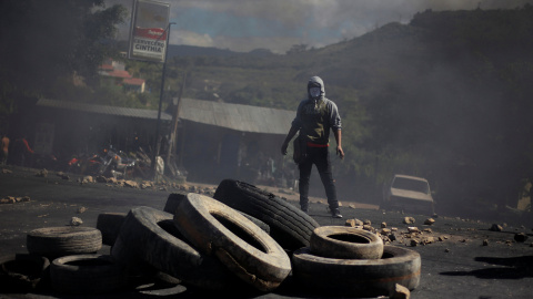 Uno de los manifestantes contra el presunto fraude electoral en Honduras tras una barricada en las calles de Tegucigalpa.REUTERS/Jorge Cabrera Uno de los manifestantes contra el presunto fraude electoral en Honduras tras una barricada en las calles de Tegucigalpa.REUTERS/Jorge Cabrera